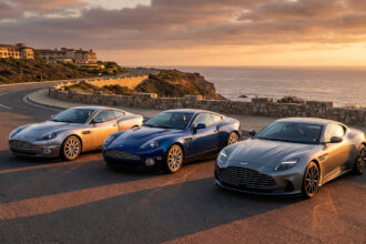 L'évolution de l'Aston Martin Vanquish : trois modèles (argent, bleu, gris) le long d'une route côtière dorée.
