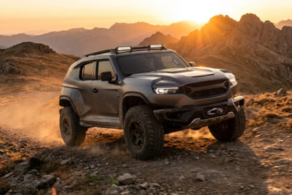 Un concept-car Mitsubishi Pajero moderne évoluant sur un sentier montagneux rocailleux au coucher du soleil.