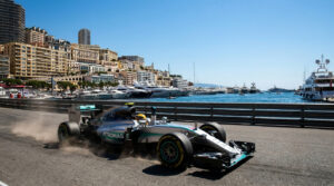 Une monoplace Mercedes de Formule 1 roulant sur le circuit urbain de Monaco avec le port et la ville en arrière-plan.