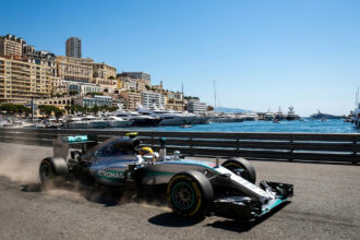 Une monoplace Mercedes de Formule 1 roulant sur le circuit urbain de Monaco avec le port et la ville en arrière-plan.