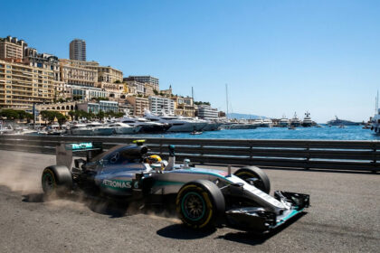 Une monoplace Mercedes de Formule 1 roulant sur le circuit urbain de Monaco avec le port et la ville en arrière-plan.