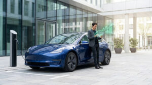 Un homme d'affaires consulte des données financières sur une tablette devant une Tesla en charge.