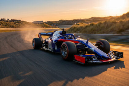 Une monoplace de Formule 1 bleue et rouge prenant un virage sur le circuit de Zandvoort au coucher du soleil.
