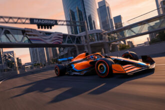 Une monoplace de Formule 1 orange et bleue en pleine accélération sur le circuit urbain du Madring au coucher du soleil.
