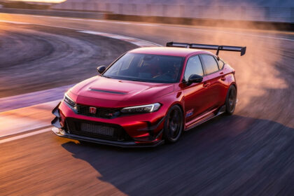 Une Honda Civic Type R rouge, version HRC, en pleine action sur un circuit automobile au coucher du soleil.